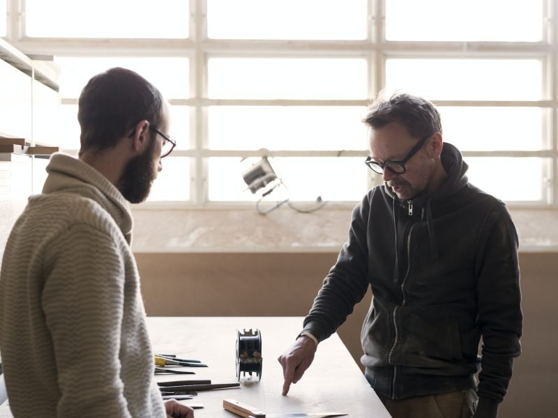 Carpenter talking to client in workshop